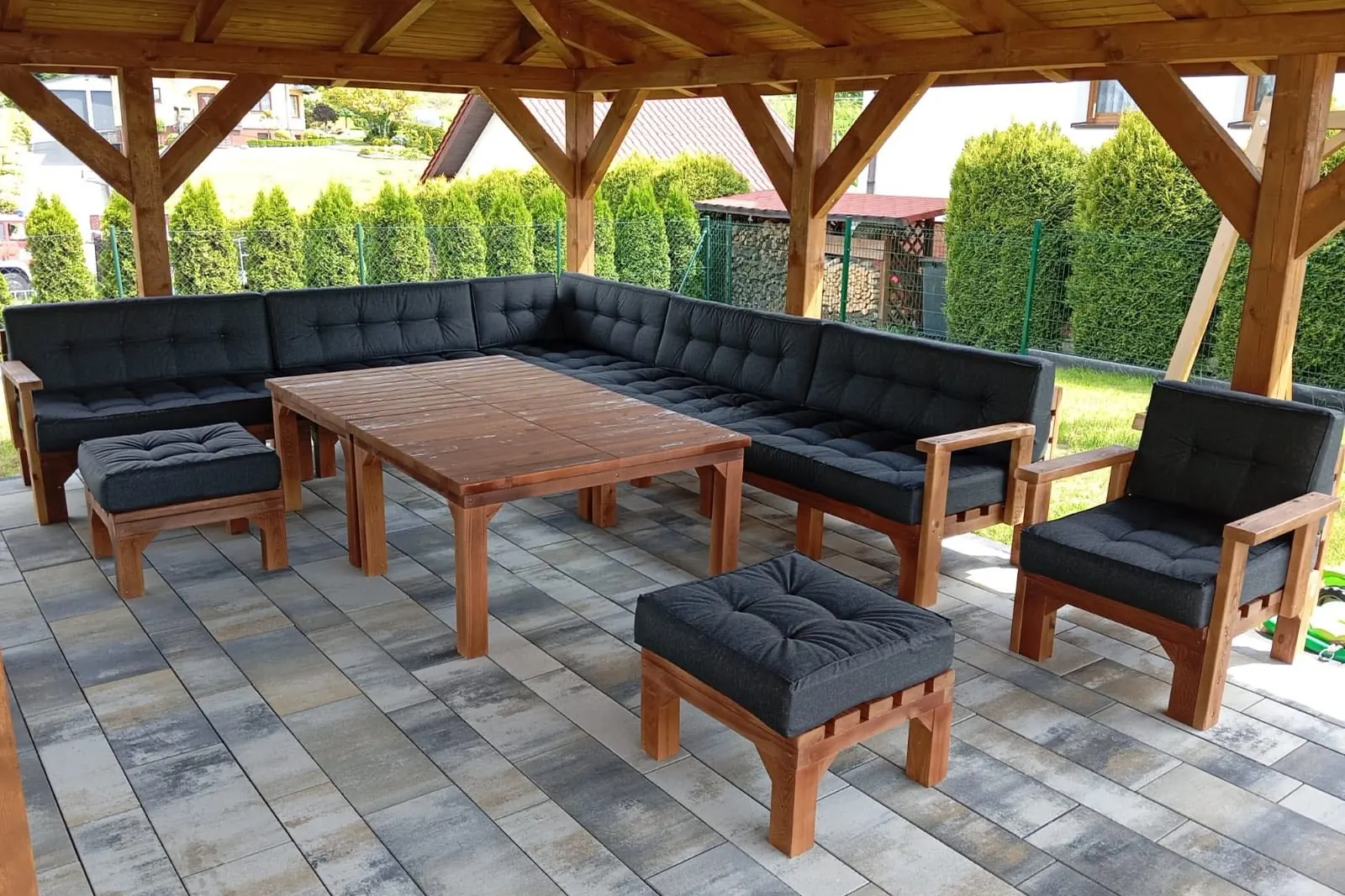 Duży zestaw: narożnik, stół, pufy i fotel pod drewnianą altaną